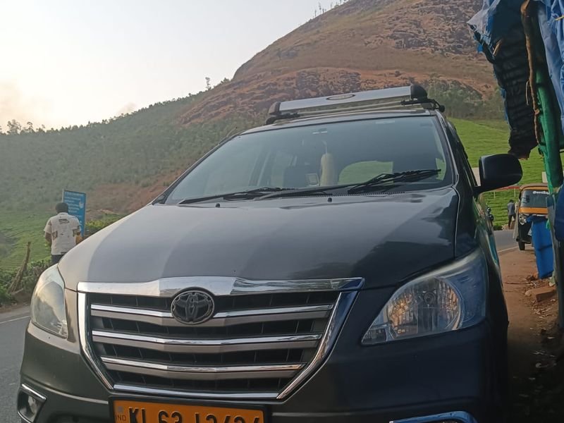 Grey sedan taxi with munnar hill view