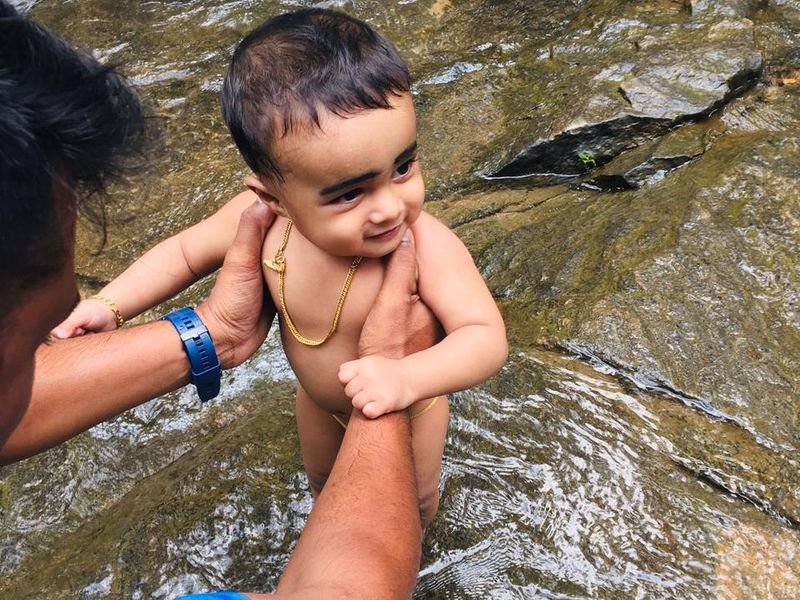 Happy baby playig in river